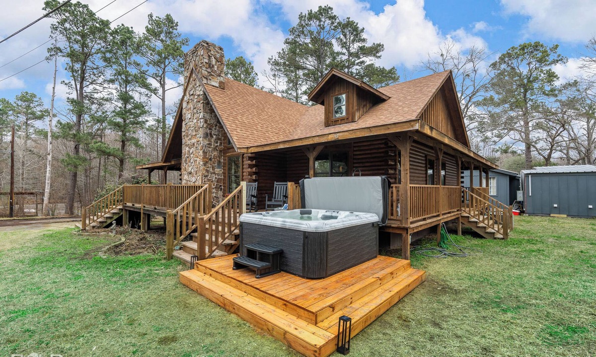 Shreveport House | Relax at this lakefront log cabin on private Emerald Isle, designed for easy outdoor living. Enjoy the hot tub, paddle out with kayaks and canoes, gather around the fire pit, or grill and unwind by the water.