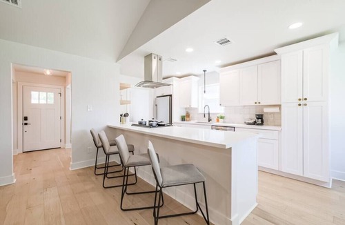 Garden Oaks House | Charming private home sleeps 8 with fenced yard, fast WiFi, smart TVs, large kitchen, and ample parking + 2-car garage—near the Heights & Downtown. Features a primary king ensuite for added privacy.