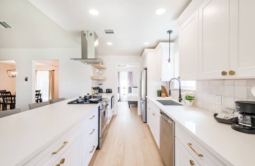 Garden Oaks House | Charming private home sleeps 8 with fenced yard, fast WiFi, smart TVs, large kitchen, and ample parking + 2-car garage—near the Heights & Downtown. Features a primary king ensuite for added privacy.