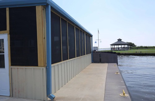 Sabine Pass Cottage | Park your boat in front of the Fishermen's Cottage! Screened in patio.