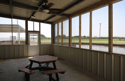 Sabine Pass Cottage | Park your boat in front of the Fishermen's Cottage! Screened in patio.