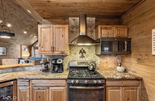 Shreveport House | Relax at this lakefront log cabin on private Emerald Isle, designed for easy outdoor living. Enjoy the hot tub, paddle out with kayaks and canoes, gather around the fire pit, or grill and unwind by the water.